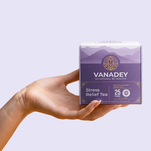 A hand holds a purple and white box of VANADEY Stress Relief Tea, which is labeled as a Premium Organic Herbal Tea containing 25 tea bags.